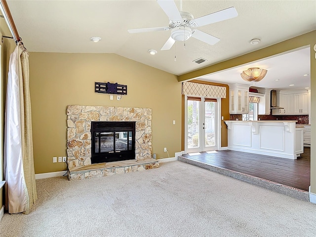 26 Creek Ct, Palm Coast, FL 32137 - unfurnished living room featuring carpet, a ceiling fan, vaulted ceiling, and a stone fireplace
