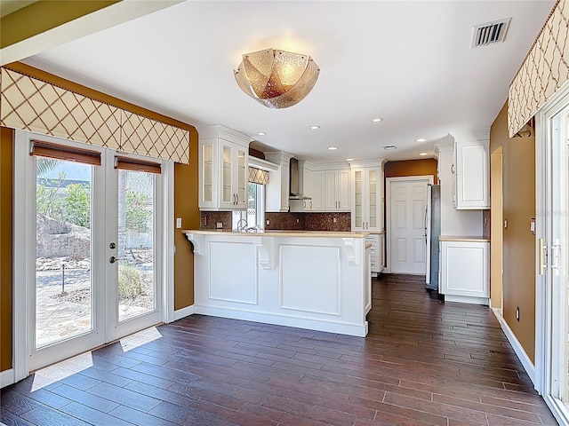 26 Creek Ct, Palm Coast, FL 32137 - kitchen with a peninsula, freestanding refrigerator, glass insert cabinets, white cabinets, and recessed lighting