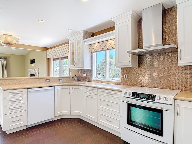 26 Creek Ct, Palm Coast, FL 32137 - kitchen with white appliances, wall chimney range hood, a peninsula, dark wood-type flooring, and white cabinetry