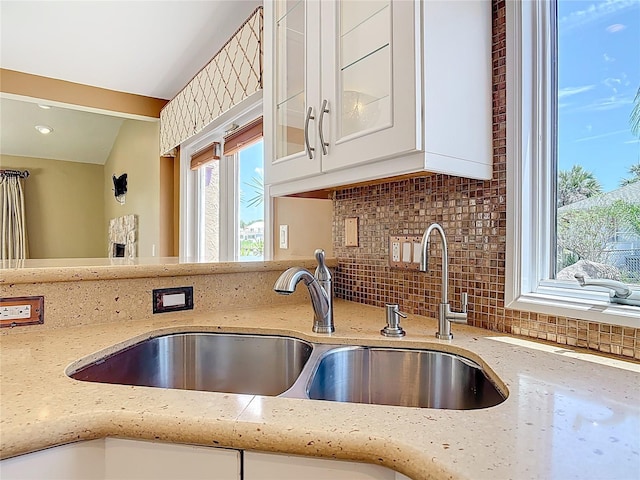 26 Creek Ct, Palm Coast, FL 32137 - kitchen with light stone countertops, decorative backsplash, white cabinets, and glass insert cabinets