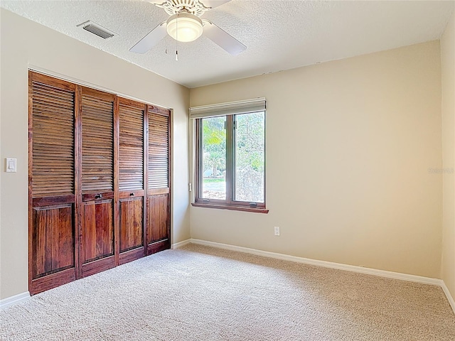 26 Creek Ct, Palm Coast, FL 32137 - unfurnished bedroom featuring a closet, carpet flooring, a textured ceiling, and ceiling fan