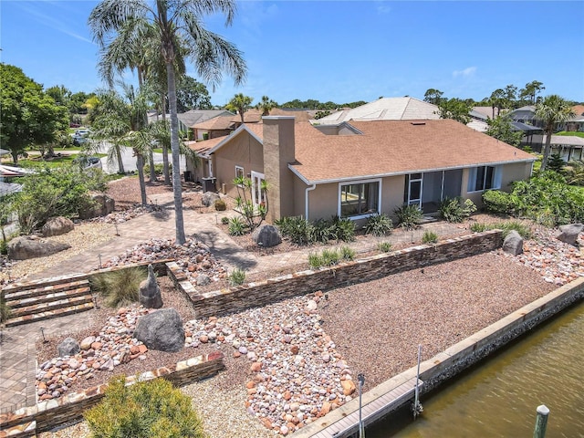 26 Creek Ct, Palm Coast, FL 32137 - rear view of house with a water view, a chimney, stucco siding, a residential view, and a shingled roof