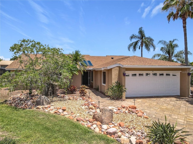 26 Creek Ct, Palm Coast, FL 32137 - single story home with stucco siding, an attached garage, solar panels, and driveway