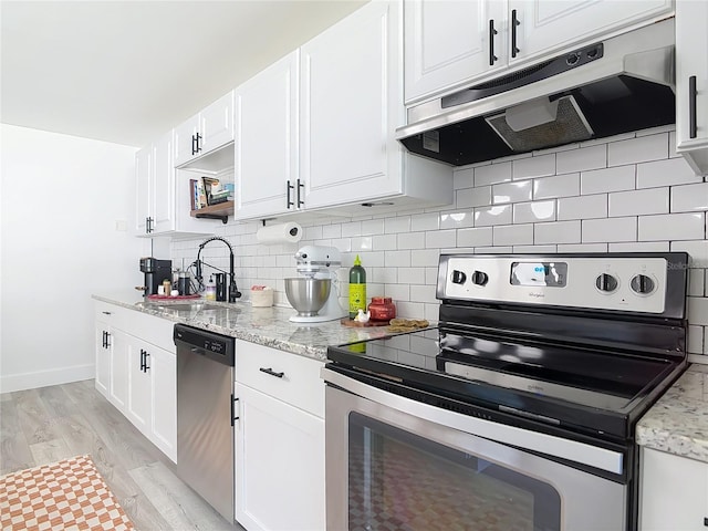1421 Pine Tree Dr, Edgewater, FL 32132 - kitchen featuring appliances with stainless steel finishes, extractor fan, decorative backsplash, white cabinets, and light stone countertops
