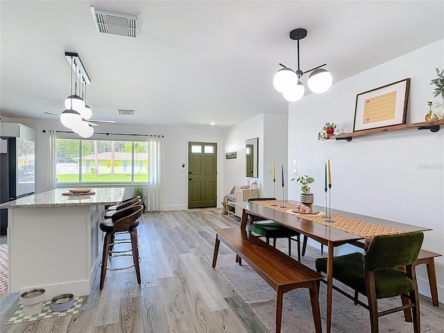 1421 Pine Tree Dr, Edgewater, FL 32132 - dining area featuring light wood finished floors, ceiling fan, and a chandelier