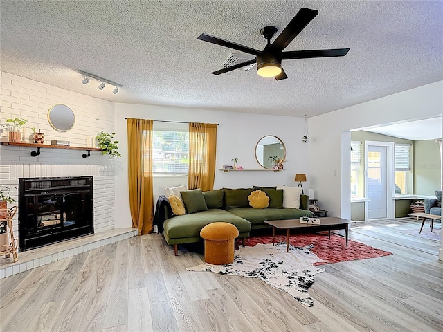 1421 Pine Tree Dr, Edgewater, FL 32132 - living area with a textured ceiling, wood finished floors, a ceiling fan, and a fireplace