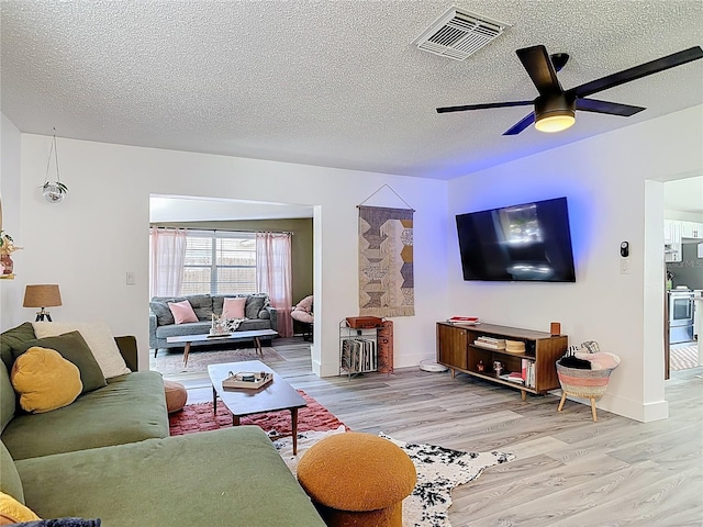 1421 Pine Tree Dr, Edgewater, FL 32132 - living area with light wood-type flooring, a textured ceiling, and a ceiling fan