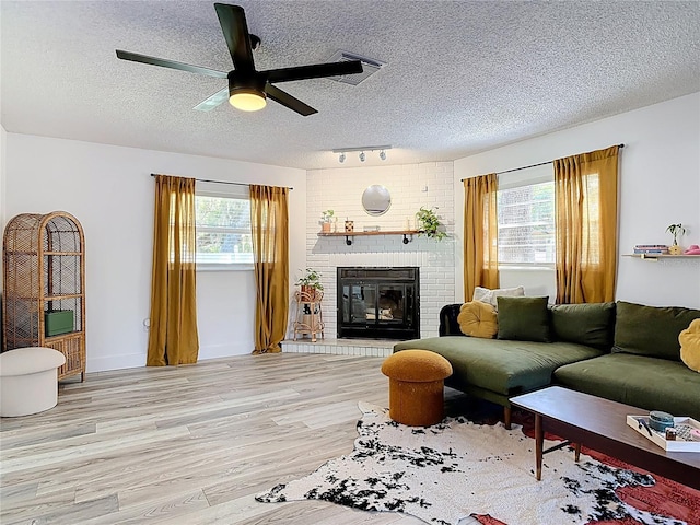 1421 Pine Tree Dr, Edgewater, FL 32132 - living area with rail lighting, a textured ceiling, light wood-type flooring, healthy amount of natural light, and ceiling fan