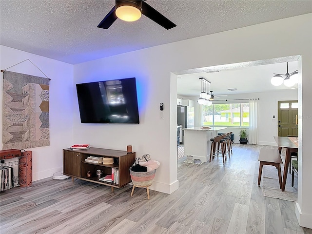 1421 Pine Tree Dr, Edgewater, FL 32132 - living room featuring light wood-style floors, ceiling fan, a textured ceiling, and a chandelier