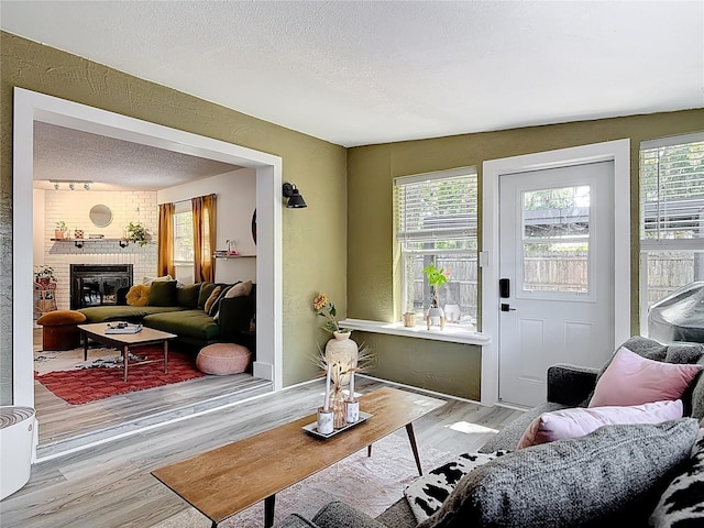1421 Pine Tree Dr, Edgewater, FL 32132 - living room with wood finished floors, a textured ceiling, and a brick fireplace