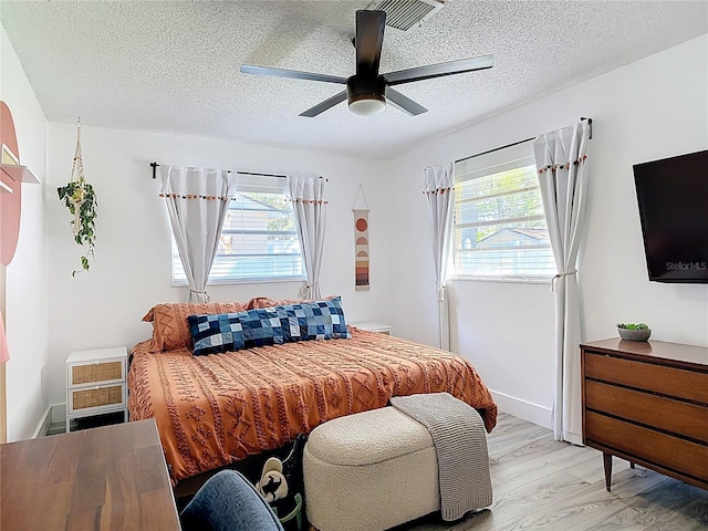 1421 Pine Tree Dr, Edgewater, FL 32132 - bedroom with a textured ceiling, light wood-style floors, and ceiling fan