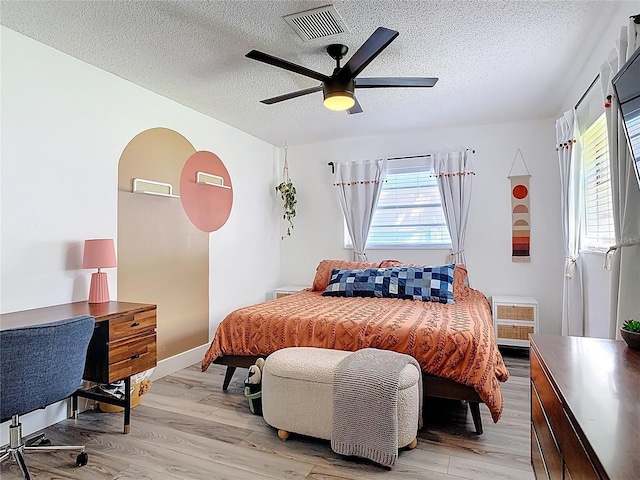 1421 Pine Tree Dr, Edgewater, FL 32132 - bedroom with multiple windows, a textured ceiling, light wood-style flooring, and ceiling fan