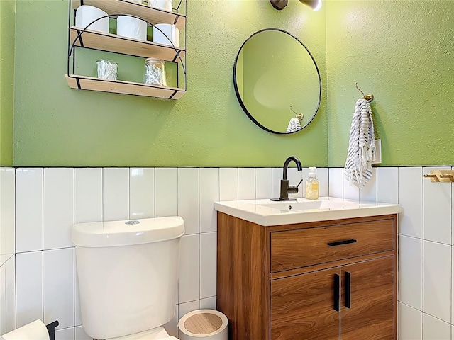 1421 Pine Tree Dr, Edgewater, FL 32132 - bathroom featuring tile walls, vanity, and a wainscoted wall