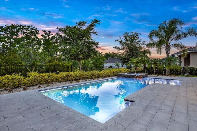 6294 W Fallsgrove Ln, Port Orange, FL 32128 - pool at dusk featuring a patio area, a pool with connected hot tub, and a fenced backyard