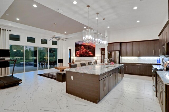 6294 W Fallsgrove Ln, Port Orange, FL 32128 - kitchen with stainless steel appliances, light marble finish floors, recessed lighting, ceiling fan, and dark brown cabinetry