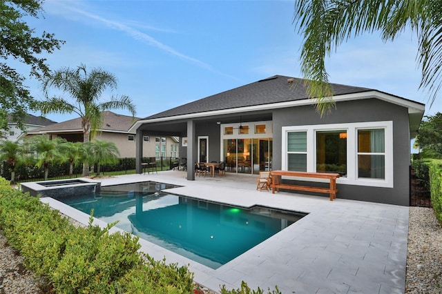 6294 W Fallsgrove Ln, Port Orange, FL 32128 - back of house featuring a patio, stucco siding, a pool with connected hot tub, and a shingled roof