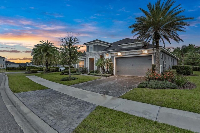 6294 W Fallsgrove Ln, Port Orange, FL 32128 - view of front of home with decorative driveway, a yard, stucco siding, a garage, and stone siding