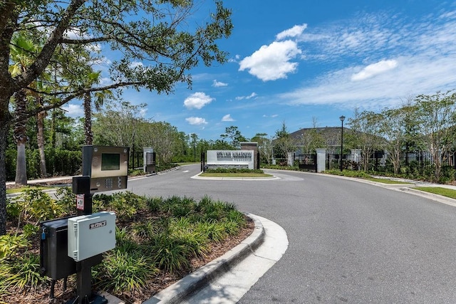 6294 W Fallsgrove Ln, Port Orange, FL 32128 - view of asphalt road featuring curbs, street lights, and a gated entry