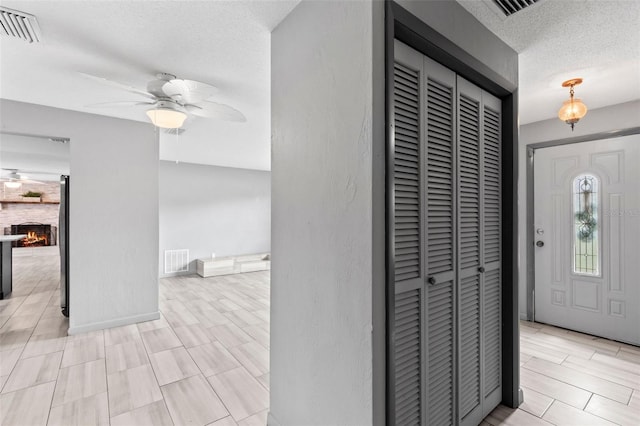 800 Black Duck Dr, Port Orange, FL 32127 - entrance foyer featuring a ceiling fan, a textured ceiling, and a fireplace