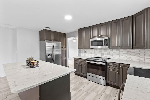 800 Black Duck Dr, Port Orange, FL 32127 - kitchen featuring appliances with stainless steel finishes, backsplash, dark brown cabinets, and recessed lighting
