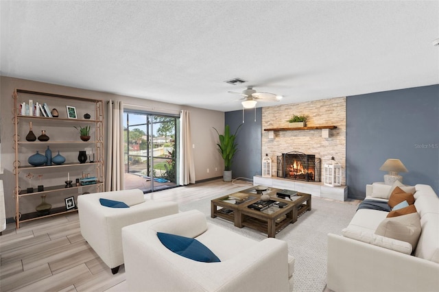 800 Black Duck Dr, Port Orange, FL 32127 - living area featuring a ceiling fan, a textured ceiling, a fireplace, and light wood-style floors