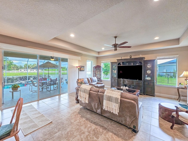 6804 Forkmead Ln, Port Orange, FL 32128 - living area featuring ceiling fan, a raised ceiling, a textured ceiling, light tile patterned flooring, and recessed lighting