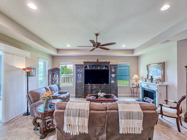 6804 Forkmead Ln, Port Orange, FL 32128 - living area featuring a ceiling fan, a high end fireplace, a textured ceiling, a tray ceiling, and recessed lighting