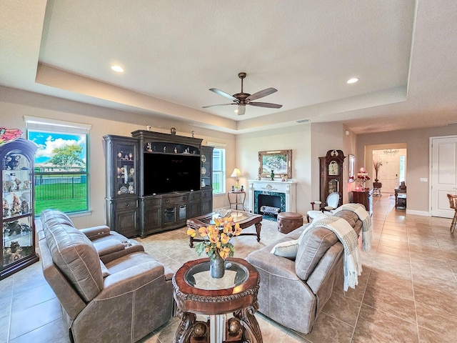 6804 Forkmead Ln, Port Orange, FL 32128 - living area featuring a raised ceiling, ceiling fan, light tile patterned floors, recessed lighting, and a fireplace