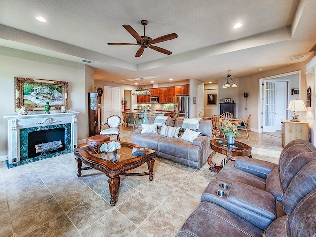 6804 Forkmead Ln, Port Orange, FL 32128 - living room with ceiling fan, a raised ceiling, recessed lighting, a premium fireplace, and light tile patterned flooring