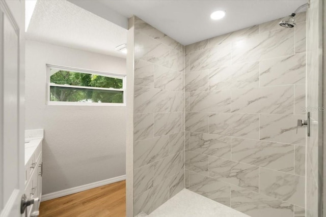 2005 Sunny Ln, New Smyrna Beach, FL 32168 - bathroom featuring tiled shower, vanity, and wood finished floors