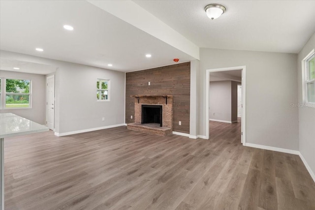 2005 Sunny Ln, New Smyrna Beach, FL 32168 - unfurnished living room with recessed lighting, plenty of natural light, a brick fireplace, and light wood-type flooring