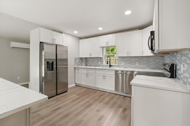 2005 Sunny Ln, New Smyrna Beach, FL 32168 - kitchen featuring appliances with stainless steel finishes, a wall mounted AC, tasteful backsplash, light wood-type flooring, and recessed lighting