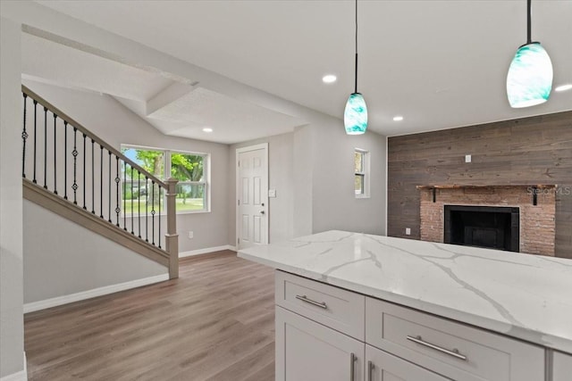 2005 Sunny Ln, New Smyrna Beach, FL 32168 - kitchen with light wood finished floors, light stone countertops, decorative light fixtures, recessed lighting, and white cabinetry