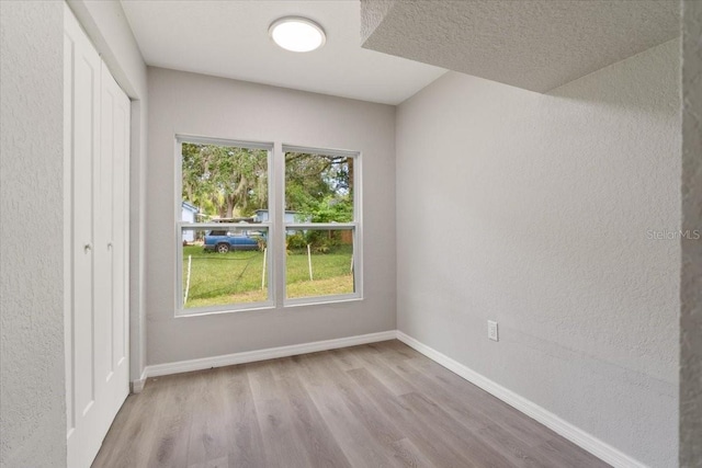 2005 Sunny Ln, New Smyrna Beach, FL 32168 - unfurnished bedroom with wood finished floors, a textured wall, and a closet