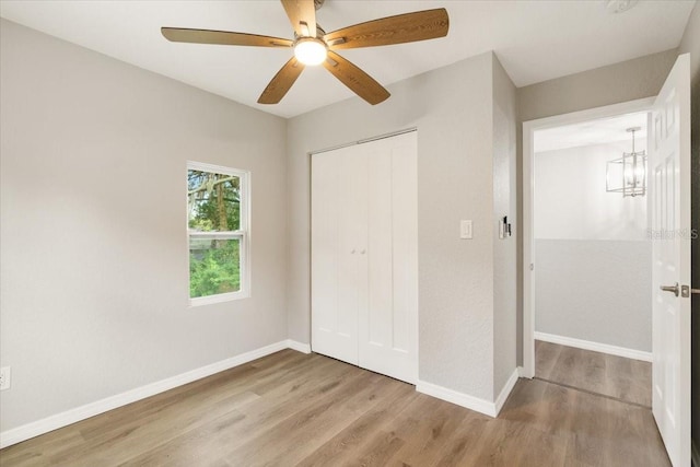 2005 Sunny Ln, New Smyrna Beach, FL 32168 - unfurnished bedroom with wood finished floors, a closet, a chandelier, and ceiling fan