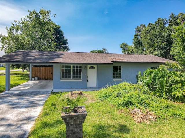 3045 Pine Tree Dr, Edgewater, FL 32141 - ranch-style home with stucco siding, concrete driveway, an attached carport, roof with shingles, and a front yard