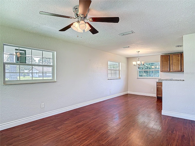 3045 Pine Tree Dr, Edgewater, FL 32141 - unfurnished room featuring a textured ceiling, a chandelier, dark wood finished floors, a textured wall, and a ceiling fan