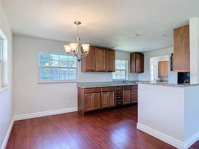 3045 Pine Tree Dr, Edgewater, FL 32141 - kitchen with dark wood-style floors, a chandelier, light stone countertops, decorative light fixtures, and a textured ceiling