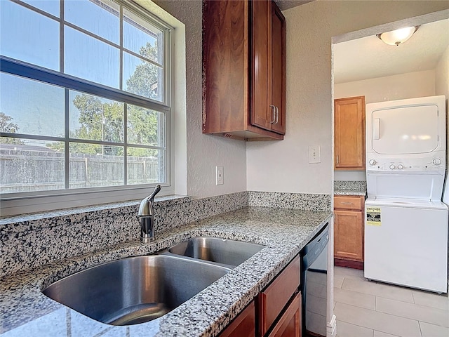 3045 Pine Tree Dr, Edgewater, FL 32141 - kitchen featuring stacked washer / dryer, dishwasher, light stone counters, and brown cabinets