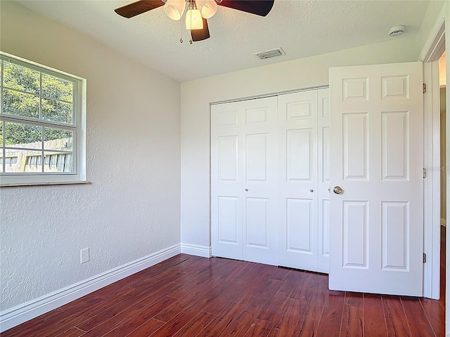 3045 Pine Tree Dr, Edgewater, FL 32141 - unfurnished bedroom featuring a closet, dark wood-type flooring, ceiling fan, and a textured ceiling