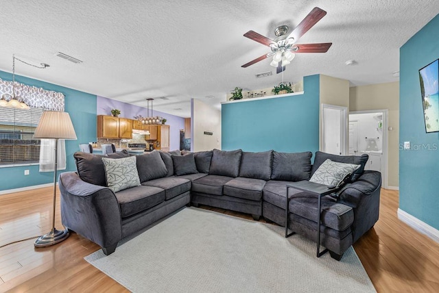 411 Ryans Ridge Ave, Eustis, FL 32726 - living area with light wood finished floors, a textured ceiling, a chandelier, and a ceiling fan
