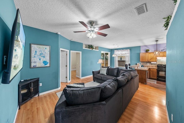 411 Ryans Ridge Ave, Eustis, FL 32726 - living area featuring ceiling fan, light wood-style floors, and a textured ceiling
