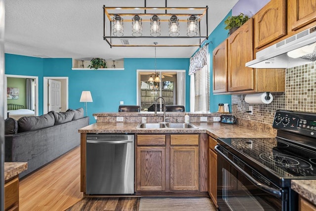 411 Ryans Ridge Ave, Eustis, FL 32726 - kitchen featuring dishwasher, electric range, under cabinet range hood, a peninsula, and decorative backsplash