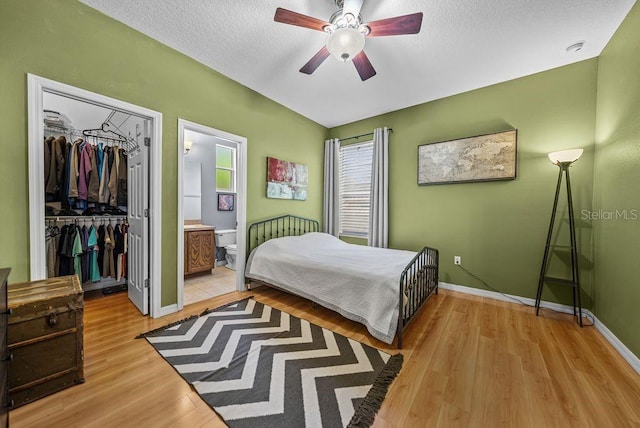 411 Ryans Ridge Ave, Eustis, FL 32726 - bedroom with a closet, light wood-style floors, a textured ceiling, ensuite bath, and ceiling fan