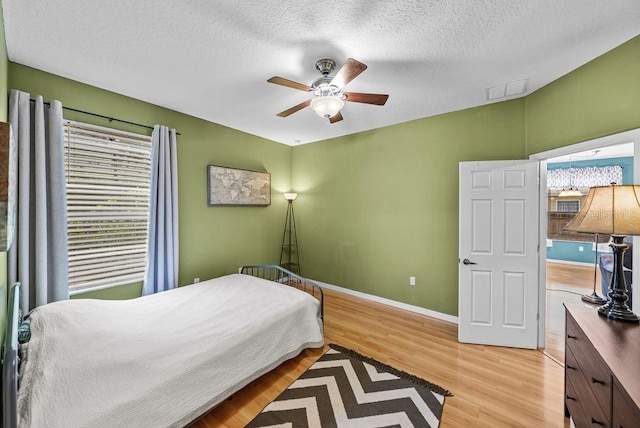 411 Ryans Ridge Ave, Eustis, FL 32726 - bedroom featuring light wood-style floors, a textured ceiling, and a ceiling fan