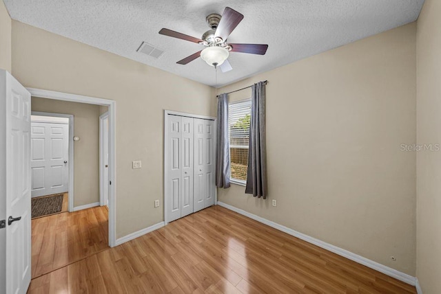 411 Ryans Ridge Ave, Eustis, FL 32726 - unfurnished bedroom with light wood-style flooring, a textured ceiling, a closet, and a ceiling fan
