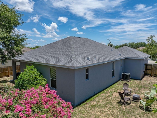 411 Ryans Ridge Ave, Eustis, FL 32726 - back of property featuring a fire pit, roof with shingles, and stucco siding