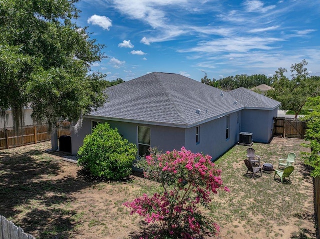 411 Ryans Ridge Ave, Eustis, FL 32726 - rear view of property featuring stucco siding, a shingled roof, a fenced backyard, and a fire pit