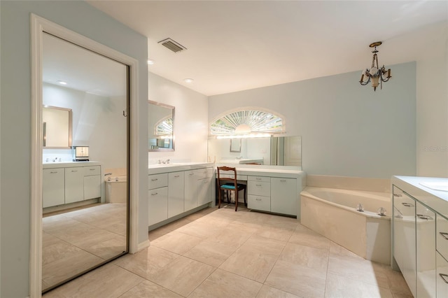 904 Clubhouse Blvd, New Smyrna Beach, FL 32168 - bathroom featuring two vanities, a bath, a chandelier, and tile patterned floors