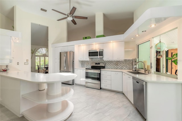 904 Clubhouse Blvd, New Smyrna Beach, FL 32168 - kitchen with appliances with stainless steel finishes, open shelves, a peninsula, tasteful backsplash, and light countertops